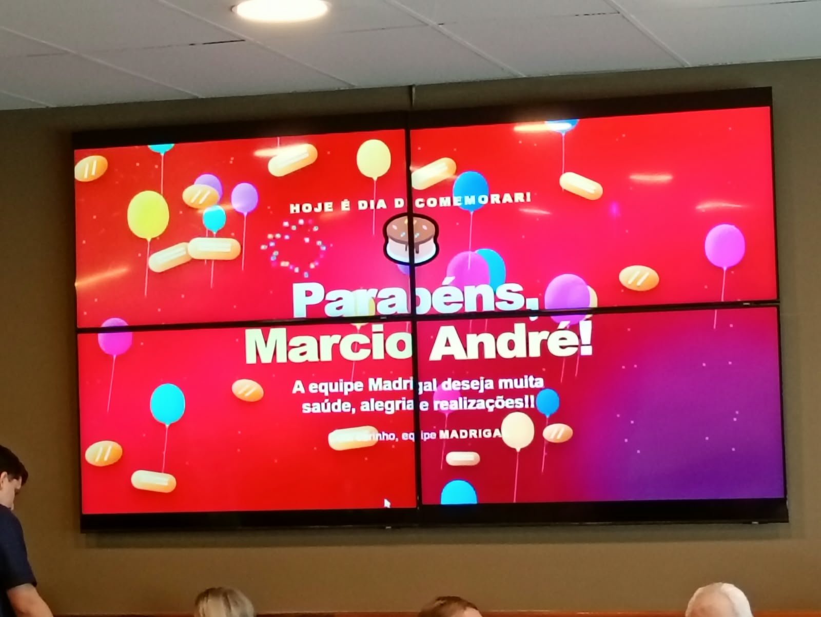 Painel TVs da Madrigal exibindo comunicado de aniversário